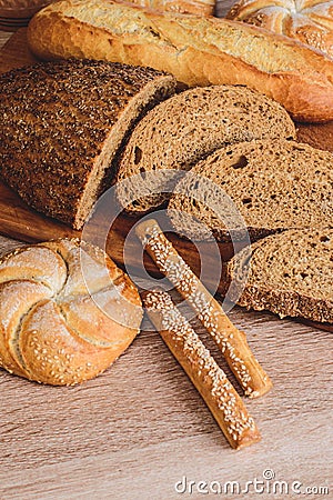 Ð¡risp bread with buns. French baguettes. Fresh crispbread. Bread background. Different breed on wooden background. Stock Photo